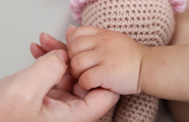 mani di mamma e figlio che si stringono