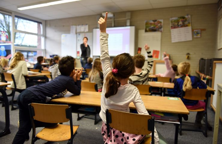 scuola bambini che alzano la mano